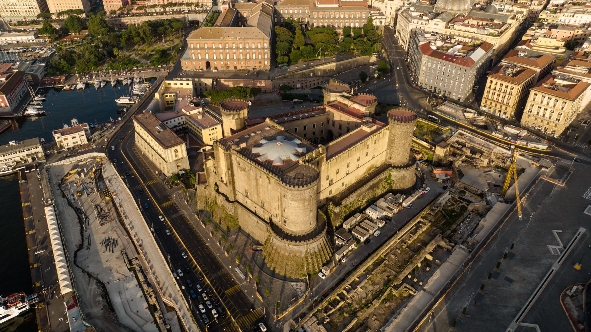 A stunning aerial view of Castel Nuovo and surrounding Naples cityscape, showcasing historic architecture.