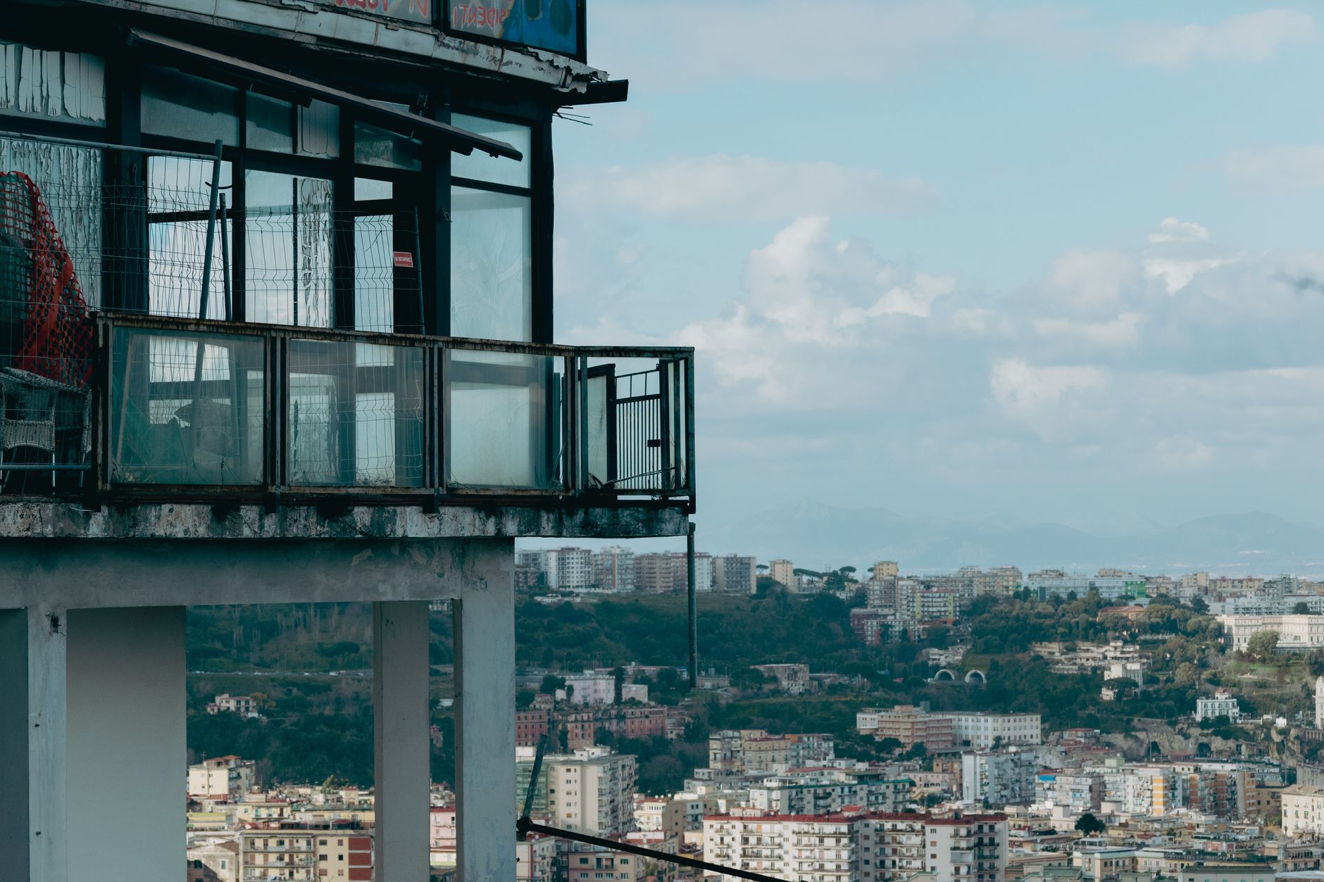 Panoramic view of Naples, Italy from a rooftop balcony, capturing urban landscape.